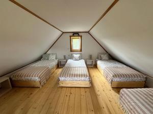 a room with three beds in a attic at Święty spokój in Nowe Motule