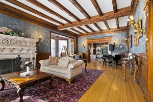 a living room with a couch and a table and a piano at Historic Salyards Mansion by Heirloom Boutique Collection in Duluth