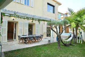 Un patio con una mesa y sillas frente a una casa. en Villa La Mascotte, en Beaulieu-sur-Mer