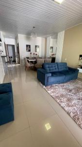 a living room with a blue couch and a table at Casa Grande com 2 quartos e 3 camas in Juazeiro do Norte