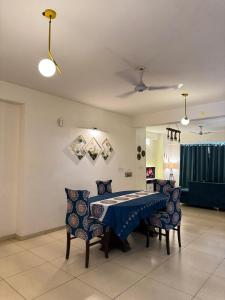 a dining room with a blue table and chairs at 3BHK Cozy Apartment in Zirakpur