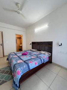 a bedroom with a large bed with a blue comforter at 3BHK Cozy Apartment in Zirakpur
