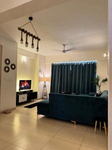 a living room with a blue couch in front of a window at 3BHK Cozy Apartment in Zirakpur