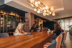 a group of people sitting at a bar with laptops at Hotel Indigo London Clerkenwell by IHG in London