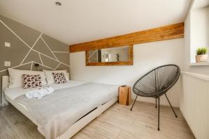 Un dormitorio con una cama grande y una silla. en Beskidzka Guest House, en Szczyrk