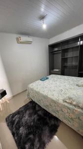 a bedroom with a bed and a rug at Casa Grande com 2 quartos e 3 camas in Juazeiro do Norte