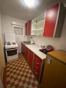 a kitchen with red cabinets and a white stove at Lana in Cetinje