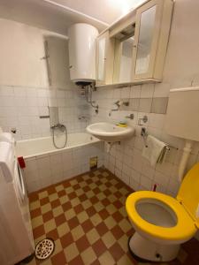 a bathroom with a yellow toilet and a sink at Lana in Cetinje