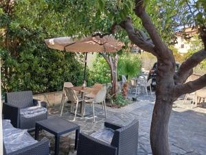 a patio with a table and chairs and an umbrella at B&B il Palazzo Cirella in Cirella