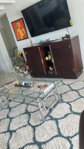 ein Wohnzimmer mit einem Glastisch und einem Flachbild-TV in der Unterkunft Ocean view in Nassau