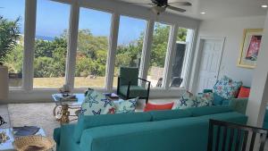 ein Wohnzimmer mit einem blauen Sofa und Fenstern in der Unterkunft Ocean view in Nassau