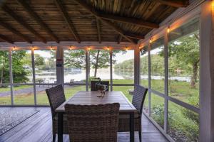 einen Tisch und Stühle auf einer Veranda mit Flussblick in der Unterkunft Lakeside Haven, a Modern Cottage with Lake Views in Effort