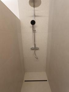 a shower in a bathroom with a shower head at Franco'gîte in Francorchamps
