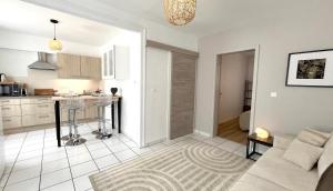 a living room with a couch and a kitchen at Gîte Le 25 in Ingersheim +3 photos
