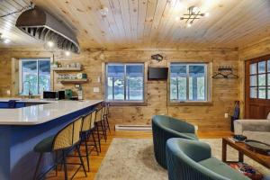 a kitchen and living room with a bar and chairs at Lakefront Haven Modern Cottage in Effort