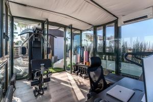 ein Fitnessstudio mit Glaswänden und Stühlen in einem Gebäude in der Unterkunft SkyJungle, luxury penthouse private pool and spa in Mailand