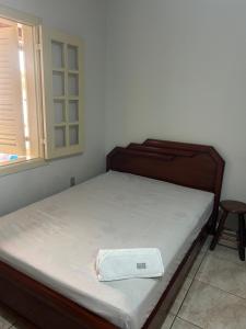 a bedroom with a bed with a wooden frame and a window at Apto com garagem em Diamantina in Diamantina