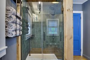 a shower with a glass door in a bathroom at Lakefront Haven Modern Cottage in Effort +87 photos