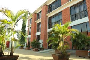 a building with palm trees in front of it at Jasmine Hotel Soroti in Soroti