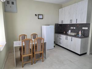 a kitchen with a table and chairs and a refrigerator at Apartman SAN, Svetosavska 15 Ljubinje in Ljubinje