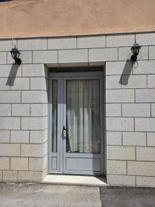 a door on a brick building with two lights at Apartman SAN, Svetosavska 15 Ljubinje in Ljubinje