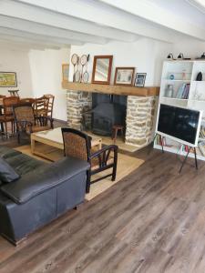 ein Wohnzimmer mit Couch und Kamin in der Unterkunft La Maison de la Grange in Moutiers-sur-le-Lay
