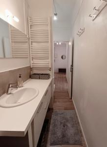 une salle de bain blanche avec un lavabo et un miroir dans l'établissement T2 Centre historique d'Aix-en-Provence, à Aix-en-Provence 13 autres photos