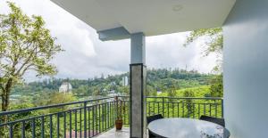 een balkon met een tafel en stoelen en uitzicht bij Royal Mist Villa- Homestay in Munnar