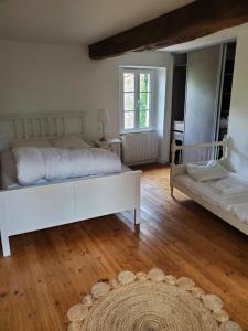 1 Schlafzimmer mit 2 weißen Betten und Holzboden in der Unterkunft La Maison de la Grange in Moutiers-sur-le-Lay