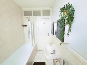 a white bathroom with a sink and a shower at Luxury 1 bed apartment in East Croydon in South Norwood