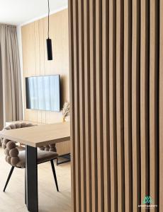eine Holzwand mit einem Holztisch und einem Stuhl in der Unterkunft APARTAMENTY SZYNDZIELNIA 2 POKOJE & BALKON & PARKING & ROWEROWNIA WORKATION Home OFFICE - NOWA NAJLEPSZA BAZA WYPADOWA W BESKIDY in Bielsko-Biała