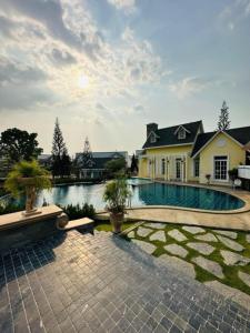 une maison avec une piscine devant une maison dans l'établissement Bristol park 237, à Ban Huai Yai