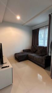 un salon avec un canapé et une télévision dans l'établissement Bristol park 237, à Ban Huai Yai