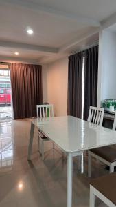 une table blanche et des chaises dans un salon dans l'établissement Bristol park 237, à Ban Huai Yai