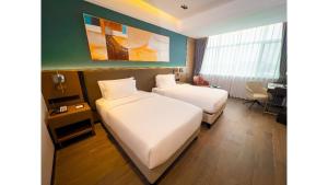 キンシャサにあるGolden Tulip Kin-Oasis Kinshasaのベッド2台と机があるホテルの部屋