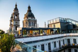 a building with a clock tower in front of a building at Aria Hotel Budapest by Library Hotel Collection in Budapest