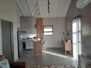 a kitchen with white cabinets and a table in a room at Endon Cottage in Bloemfontein