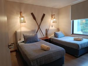 a room with two beds and two lamps and a window at HOM I Depto Familiar con parking incluido in Puerto Varas