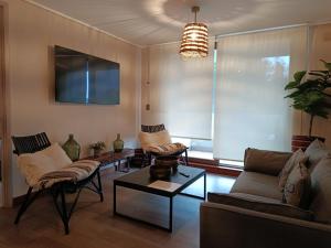 a living room with two couches and a tv at HOM I Depto Familiar con parking incluido in Puerto Varas