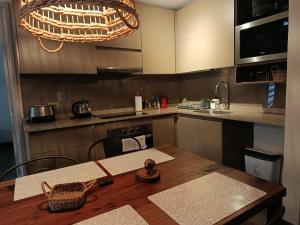 a kitchen with a wooden table and a sink at HOM I Depto Familiar con parking incluido in Puerto Varas