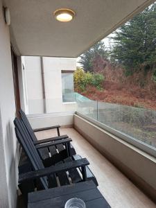 a pair of chairs sitting on a balcony with a window at HOM I Depto Familiar con parking incluido in Puerto Varas +27 photos