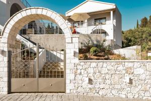 a gate to a house with a stone wall at Ostria Village in Syvota