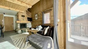 a living room with a couch and a fireplace at Chalet Soleil, magnifique triplex sur les pistes in La Rosière