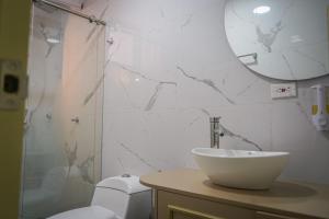 łazienka z umywalką, toaletą i lustrem w obiekcie Hotel Chromatic w mieście Guatapé