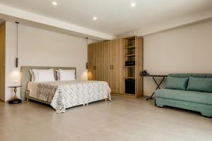a bedroom with a bed and a blue couch at Ostria Village in Syvota +20 photos