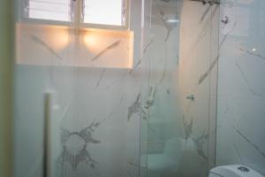 łazienka z prysznicem i szklanymi drzwiami w obiekcie Hotel Chromatic w mieście Guatapé