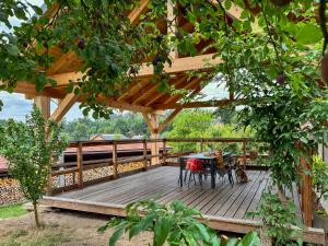 a wooden deck with a table and chairs on it at Stylová Lodge s vlastním koupáním, krbem & Netflix in Varvažov