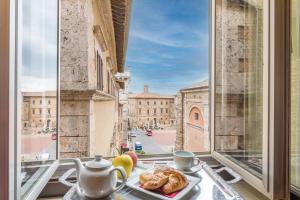an open window with a plate of food on a table at Bellarmino Boutique Apartments, Montepulciano in Montepulciano