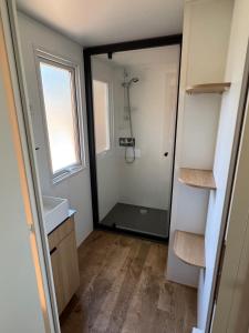 a bathroom with a shower and a glass door at Mobil-home - Valras Plage - Les Sables du Midi 4 étoiles in Sérignan