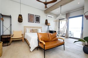 a bedroom with a bed and a chair at Serenity Terraces Beach, Resort in Kokrobite